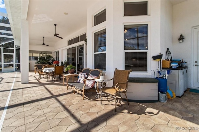 view of patio / terrace with glass enclosure, ceiling fan, and outdoor dining space