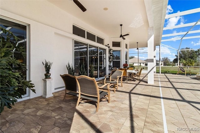 view of patio featuring a lanai and a ceiling fan