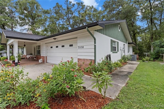 3550 S Dean Ter, Inverness, FL 34452 - view of side of property with an attached garage, driveway, a chimney, ceiling fan, and board and batten siding