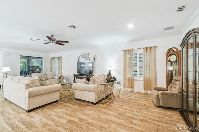 living room with light wood-style floors, plenty of natural light, visible vents, and ornamental molding