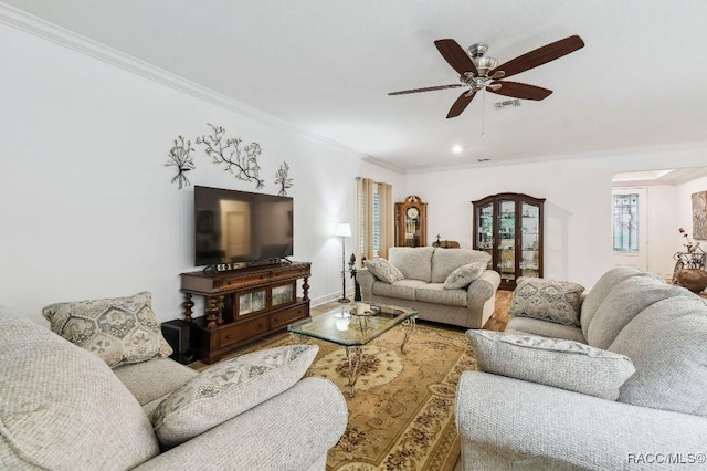 living room featuring baseboards, visible vents, ceiling fan, wood finished floors, and crown molding