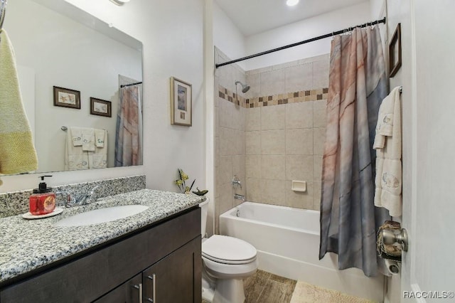 full bathroom with toilet, shower / tub combo, wood finished floors, and vanity