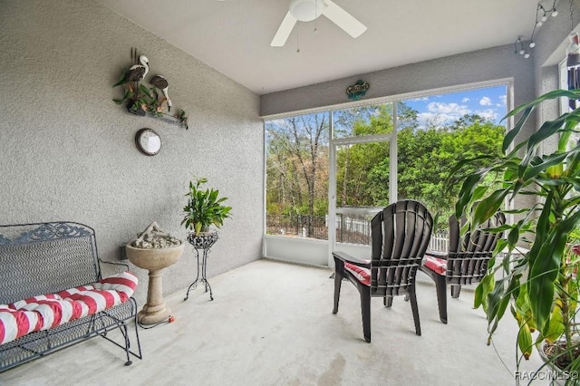 sunroom / solarium featuring a ceiling fan