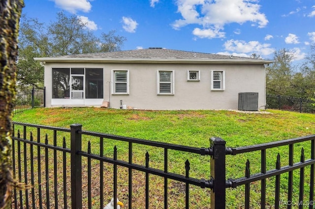 back of property with a yard, a fenced backyard, and a sunroom