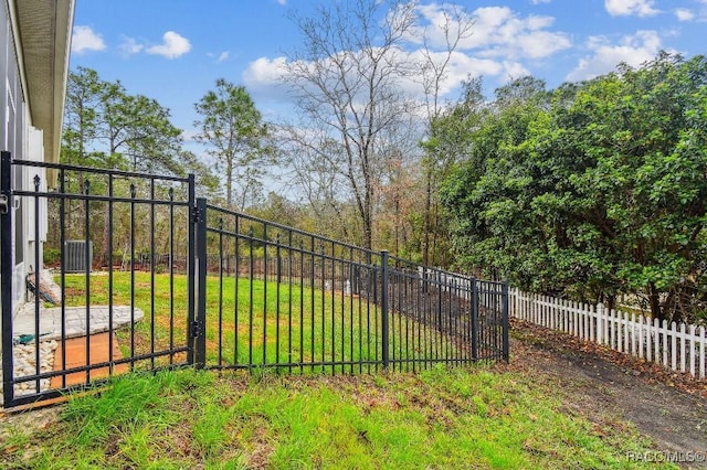 view of gate with a yard and fence