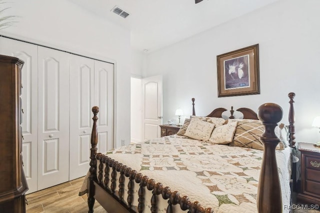 bedroom with light wood-style floors, a closet, and visible vents