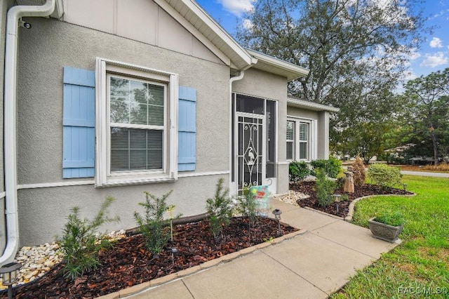 entrance to property featuring stucco siding