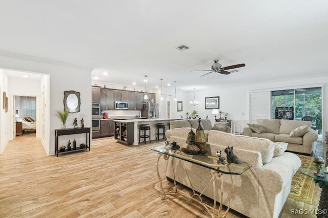 living area with light wood finished floors, visible vents, a ceiling fan, and recessed lighting