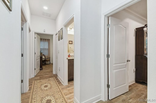 hallway featuring baseboards, recessed lighting, visible vents, and light wood-style floors