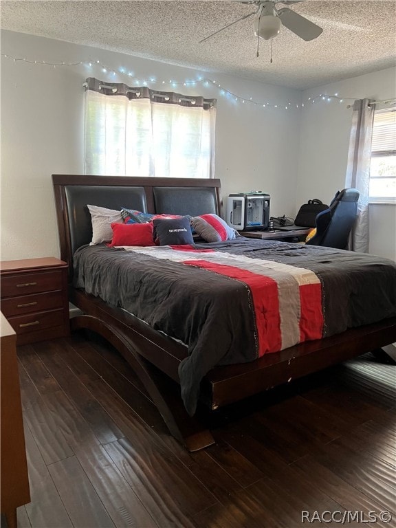 bedroom with dark hardwood / wood-style flooring, a textured ceiling, and ceiling fan