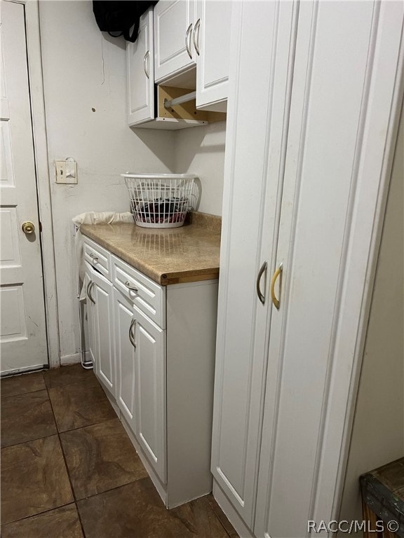 kitchen featuring white cabinets and dark tile patterned floors