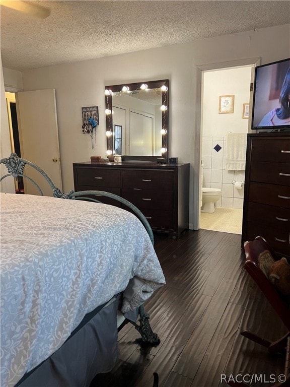 bedroom featuring a textured ceiling, dark hardwood / wood-style floors, and ensuite bathroom