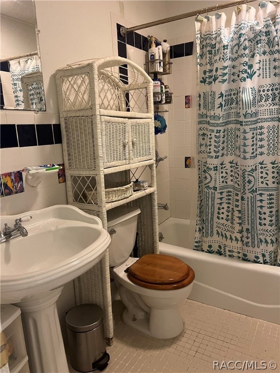 bathroom featuring tile patterned floors, shower / bath combination with curtain, and toilet