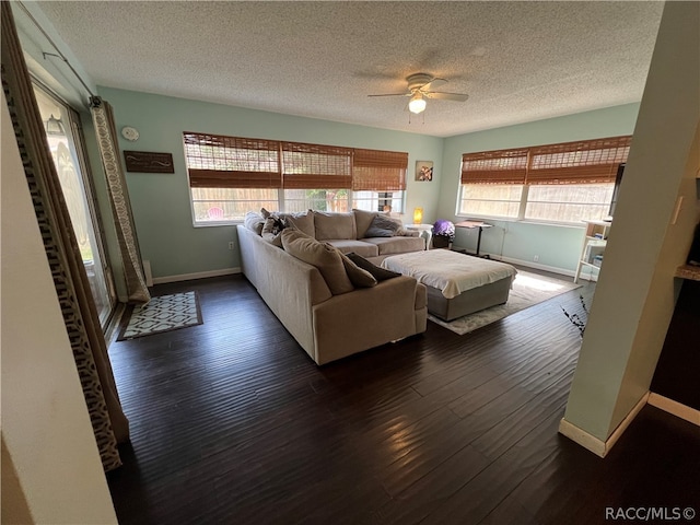 living room featuring a textured ceiling, dark hardwood / wood-style flooring, and plenty of natural light