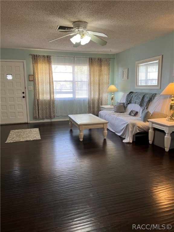 interior space with a textured ceiling, multiple windows, and ceiling fan