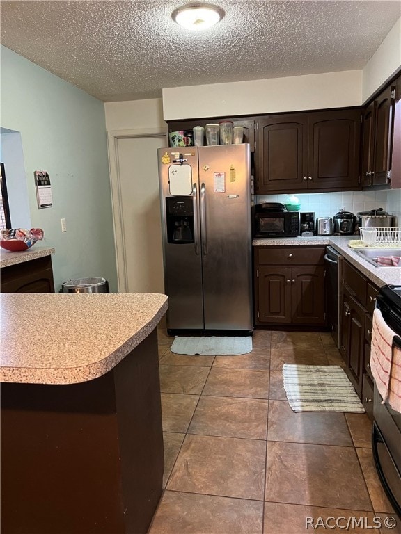 kitchen featuring dark brown cabinets, tile patterned flooring, a textured ceiling, and appliances with stainless steel finishes