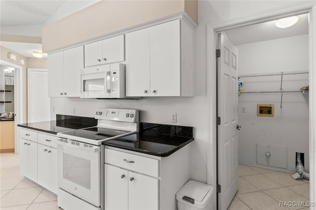 3874 E Lake Todd Dr, Hernando, FL 34442 - kitchen with white appliances, light tile patterned floors, dark countertops, and white cabinets