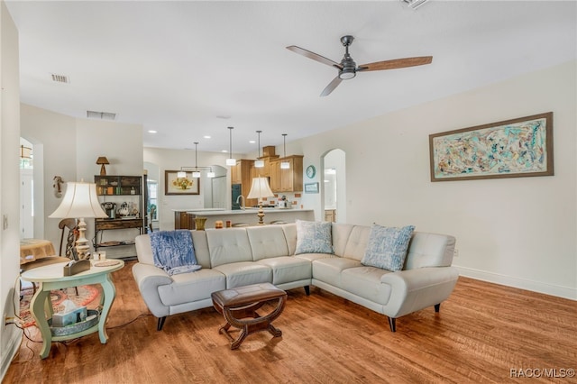 living room featuring ceiling fan and light wood-type flooring