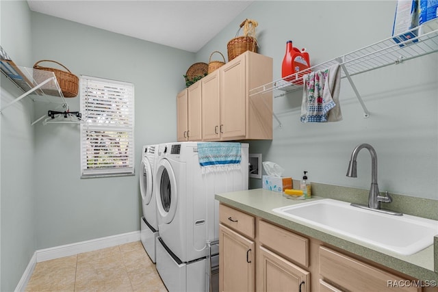 washroom featuring cabinets, sink, washing machine and dryer, and light tile patterned floors