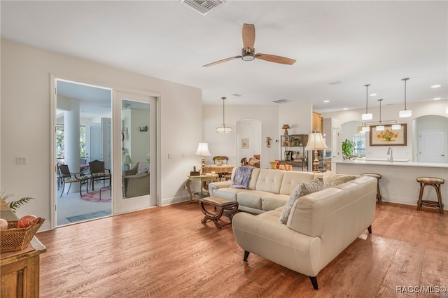 living room featuring ceiling fan and light hardwood / wood-style floors