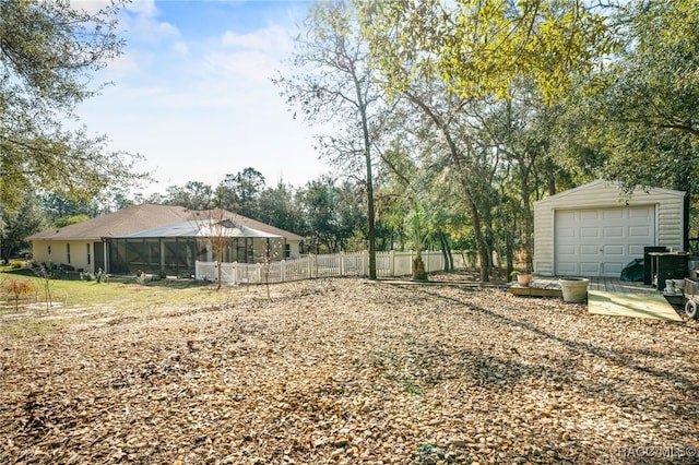 view of yard with a garage and glass enclosure