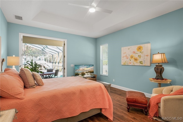 bedroom featuring dark wood-type flooring, ceiling fan, and a tray ceiling