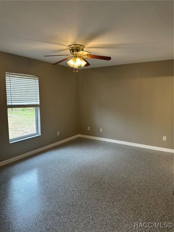 empty room with a textured ceiling and ceiling fan