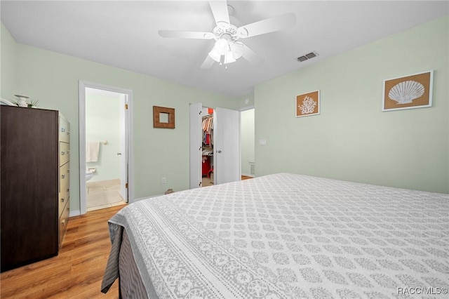 8917 SW 101st Ln, Ocala, FL 34481 - bedroom with a walk in closet, light wood-style flooring, ensuite bathroom, visible vents, and ceiling fan