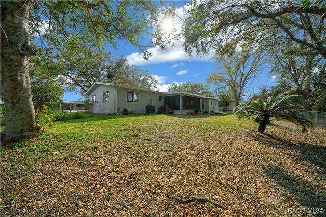 8917 SW 101st Ln, Ocala, FL 34481 - view of yard with central air condition unit, a sunroom, and fence