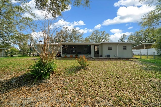 8917 SW 101st Ln, Ocala, FL 34481 - back of house featuring a sunroom, fence, and a lawn