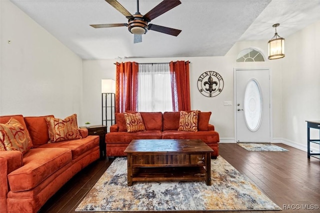 living area featuring vaulted ceiling, dark wood finished floors, baseboards, and ceiling fan