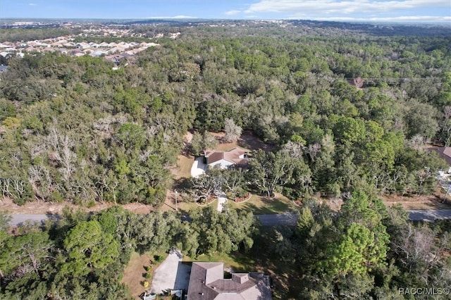 birds eye view of property featuring a forest view