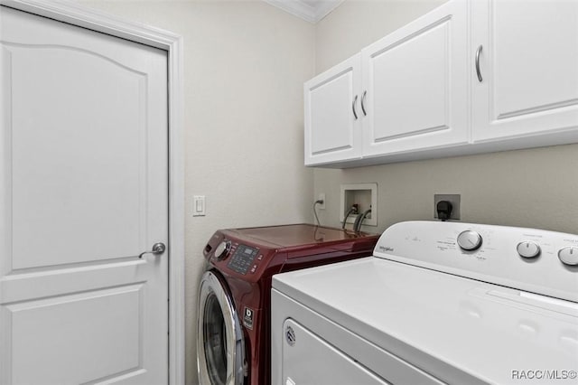 clothes washing area featuring separate washer and dryer and cabinet space