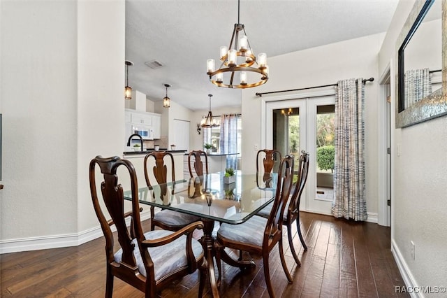 dining space featuring a chandelier, dark wood-style floors, visible vents, and baseboards