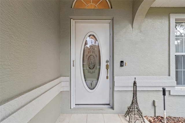 view of exterior entry featuring stucco siding