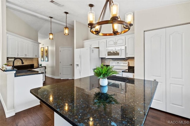 kitchen featuring white appliances, a sink, visible vents, white cabinets, and decorative light fixtures