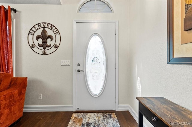 foyer featuring baseboards and dark wood finished floors