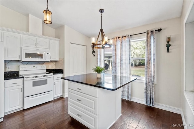 kitchen with pendant lighting, white appliances, dark countertops, and white cabinets