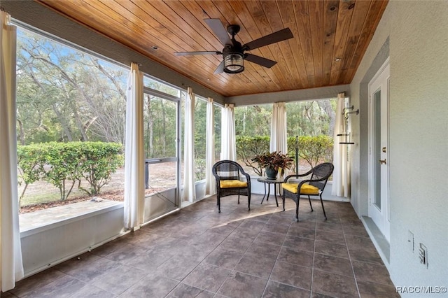 sunroom with ceiling fan, wooden ceiling, and a healthy amount of sunlight