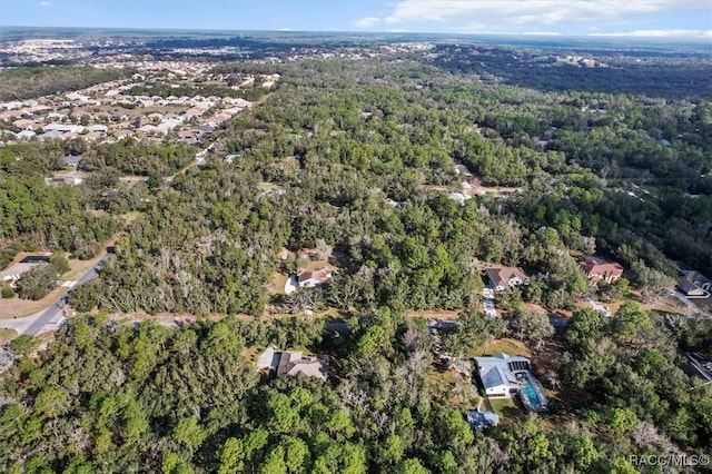 drone / aerial view featuring a wooded view