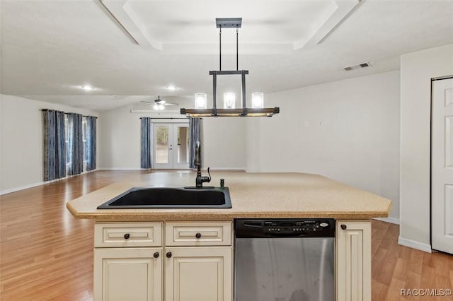 kitchen featuring an island with sink, open floor plan, dishwasher, and light countertops