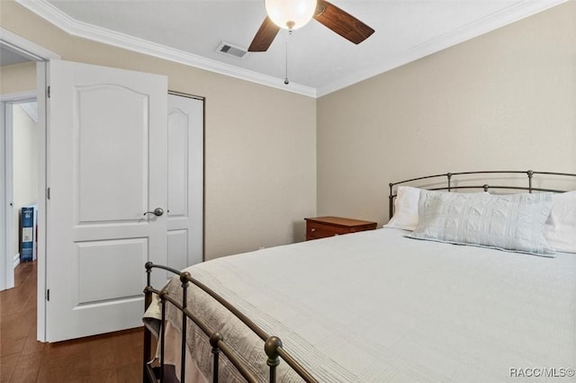 bedroom featuring a ceiling fan, visible vents, dark wood-type flooring, and ornamental molding