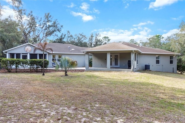 back of house with a yard, central AC unit, and stucco siding