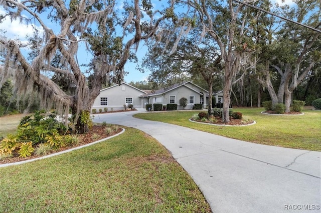 single story home with driveway and a front lawn