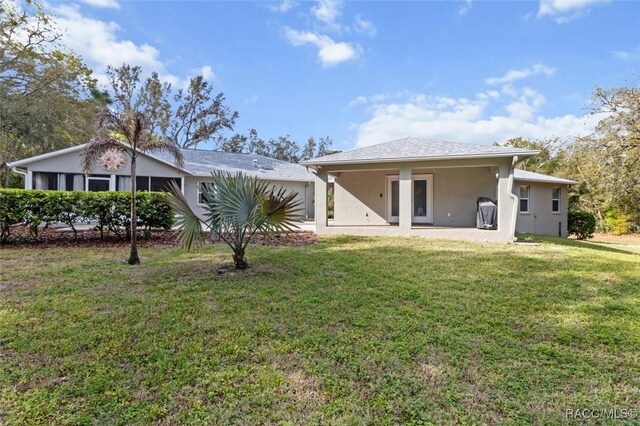 919 W Pearson St, Hernando, FL 34442 - rear view of property featuring a yard, an attached garage, a patio, and stucco siding