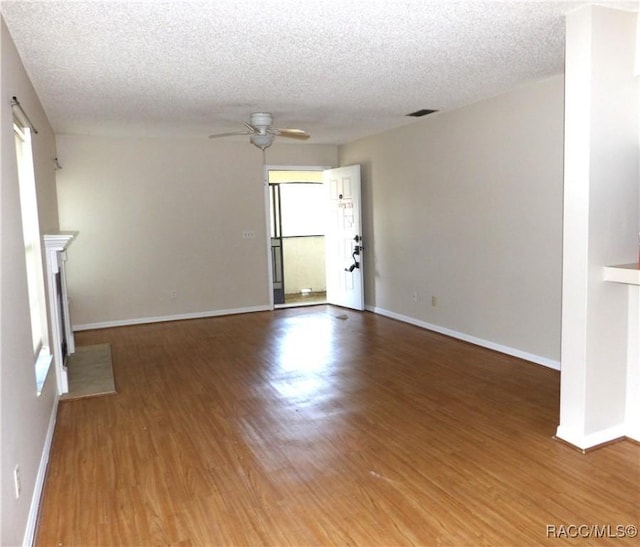 unfurnished living room with wood-type flooring, a textured ceiling, and ceiling fan