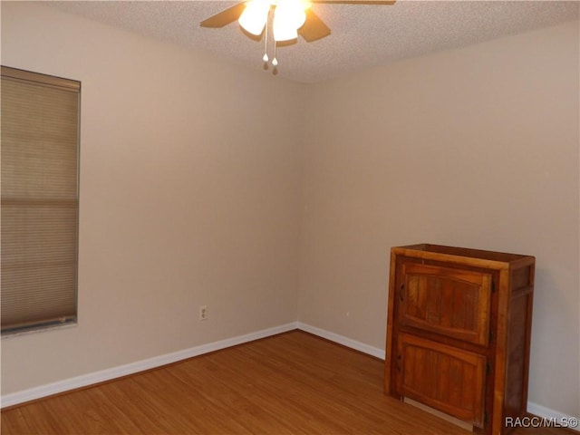 unfurnished room featuring ceiling fan, hardwood / wood-style floors, and a textured ceiling