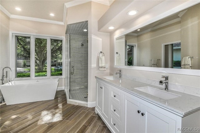 bathroom with hardwood / wood-style floors, vanity, shower with separate bathtub, and crown molding