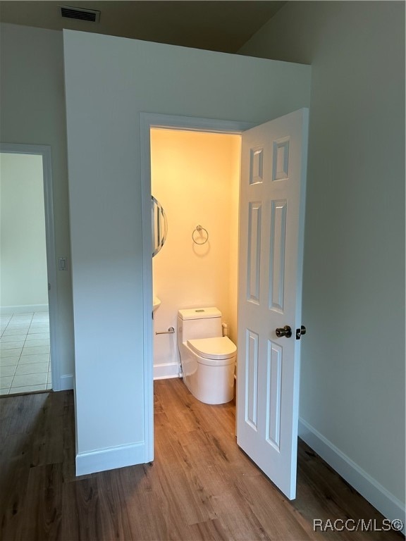 bathroom featuring toilet and hardwood / wood-style flooring