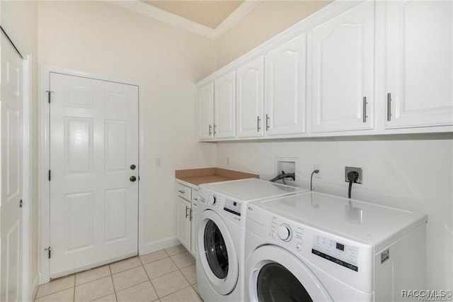 washroom featuring cabinets, washer and clothes dryer, and light tile patterned flooring